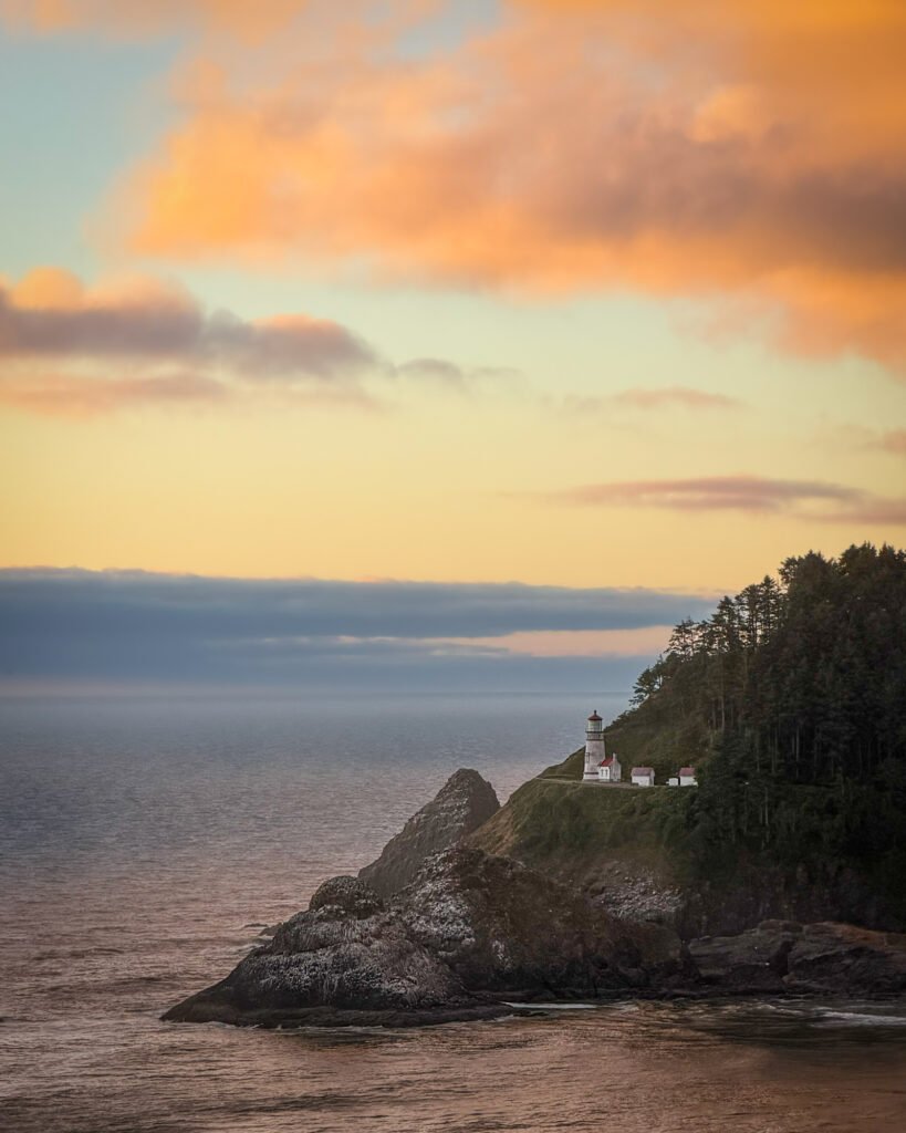 Heceta Head Lighthouse on the Oregon coast at sunset, overlooking the Pacific Ocean.